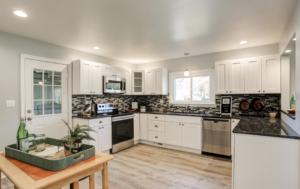 Kitchen remodel with white cabinetry and tile backsplash